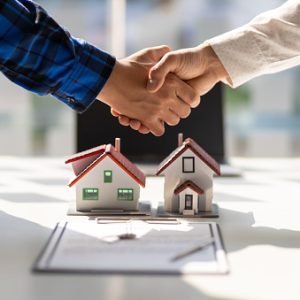 Real estate agents shake hands after the signing of the contract agreement is complete.